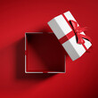 Top view of  open gift box or present box with red ribbon and bow  on red background with shadow