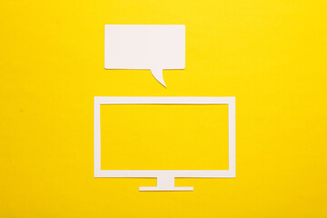 Paper-cut icon of modern TV set with speech bubble on yellow background