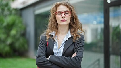 Poster - Young woman business worker standing with arms crossed gesture and serious face at street