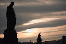 Silhouette Of Statues And Buildings At Sunset; Prague, Czech Republic