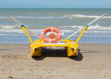 A Lifeboat Sitting On The Beach At The Water's Edge; Rimini, Emilia-Romagna, Italy