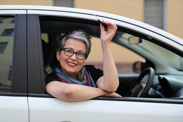 Poster - A mature, happy Caucasian woman, enjoying her journey in a new car, symbolizing independence and happiness.