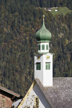 Church Steeple With Tree Covered Mountain Slope In Autumn; Aschau, Austria