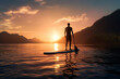 Silhouette of stand up paddle boarder paddling on a quiet sea with warm summer sunset colors. Sport and Relax Concept.
