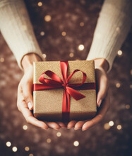 Female Hands Holding Gift Box With Red Ribbon