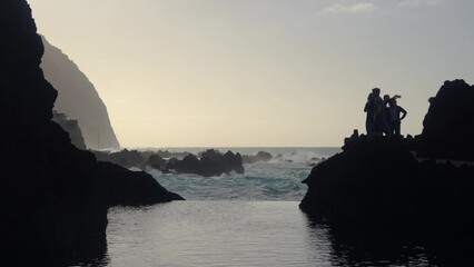 Wall Mural - Footage of people watching the waves crashing off the north coast of Madeira at Porto Moniz on cloudy day