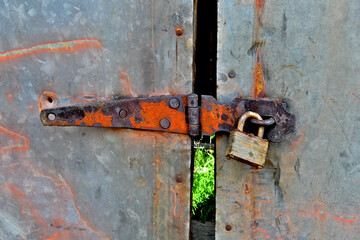 Old hasp and paddle lock on metal sliding doors 