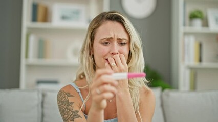 Wall Mural - Young blonde woman waiting for pregnancy result test nervous at home