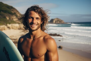 Wall Mural - Smiling portrait of a happy male caucasian surfer on a sandy beach