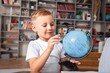 © BillionPhotos.com - Little schoolchild learning with globe model