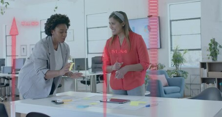 Canvas Print - Red upward arrows over happy diverse female colleagues brainstorming at casual office