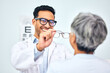 © Phindulo T/peopleimages.com - Glasses, optometrist and client with appointment, vision and consultation with diagnosis, smile and help. Office, employee and senior woman with eyewear, doctor and healthcare with wellness and frame