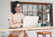 © panadesignteam - Young asian woman using laptop at a cafe