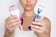 © Марина Демешко - Cropped shot of young caucasian woman holding epilator and blue reusable razor for shaving offering a choice on a white background. Getting rid of unwanted hair