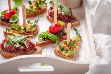 Wall Mural - Tasty bruschetta with tartare and scrambled eggs for a snack