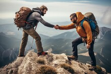 A hiker extends a helping hand to assist a friend in reaching the mountaintop.
