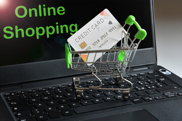 Shopping online, paying online with credit card. Shopping cart with credit card on a laptop keyboard with the text 