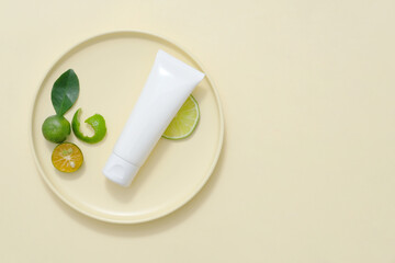 Sticker - Plastic bottle displayed with kumquat slices and green leaves on beige background. Minimal background with copy space for cosmetics, business branding and product presentation