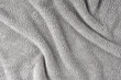 Terry cloth, gray towel texture background. Wrinkled and crumped soft fluffy textile bath or beach towel material. Top view, close up.