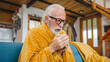 © Miljan Živković - one senior man sit on sofa bed hold cup of tea common cold sneezing