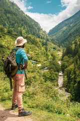 Back view of male traveler standing in green valley looking at Wae Rebo village with traditional houses surrounding amazing mountains during vacation. Go Everywhere and enjoying freed, Himachal prades