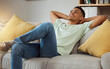 © Mumtaaz D/peopleimages.com - Relax, calm and man in a sofa happy, chilling and enjoy weekend freedom at home. Resting, peace and male person in a living room with break, day off or weekend me time, smile and stress free in house