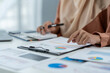 © crizzystudio - Motivated muslim businesswoman wearing hijab working on real estate project analyzing document data graph discussing presentation work income calculation tax to company in office.