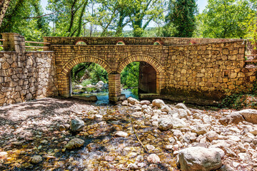 Wall Mural - Old, stone, arched bridge across the river near Agia Theodora of Vasta church in Peloponnese, Greece.