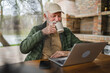 © Miljan Živković - One senior man sit outdoor in autumn day hold cup of coffee or tea