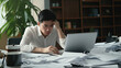 © Sasint - Frustrated Asian young businessman worker working on table in office. Busy employee worker people feel tired and headache from late work and overwork job document on computer desk at company workplace