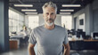 © Stock'd  - portrait of creative older man at work wearing a gray tshirt and jeans smiling to camera in casual office
