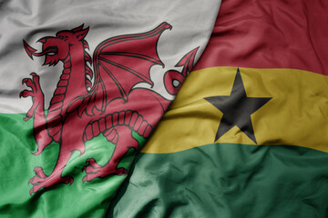 big waving national colorful flag of wales and national flag of ghana .