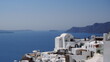 Beautiful Oia town on Santorini island, Greece. Traditional white architecture  and greek orthodox churches with blue domes over the Caldera, Aegean sea. Scenic travel background.