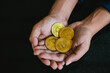 a man holding golden coins with the bitcoin symbol