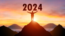 Silhouette Of Man On The Top Of The Mountain With The Beginning Of New Year 2024 Number Background.