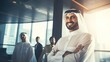 Emirati Arab at office wearing Kandura looking at front ideal for Middle East business concept. Arabic man inside a corporate establishment with colleagues at the background. generative ai