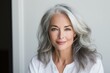 © Fotograf - A picture of a woman with grey hair wearing a white shirt. This image can be used to depict elegance, maturity, or professionalism.