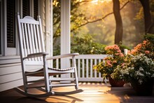 A Comfortable Rocking Chair Sits On A Porch, Accompanied By A Potted Plant. This Image Is Perfect For Showcasing Relaxation And A Peaceful Outdoor Setting.