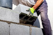 A builder lays an aerated concrete block on a wall