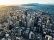 Aerial view of downtown skyscrapers at sunset. Sea bay with islands and hilly landscape in background. San Francisco, California, USA