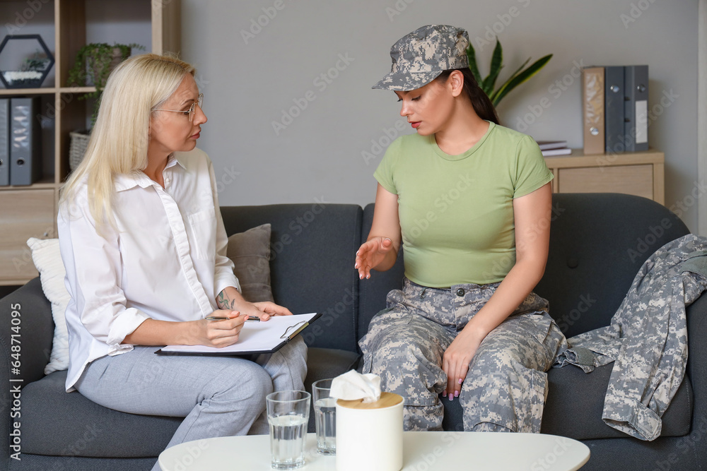 Mature psychologist working with female soldier in office