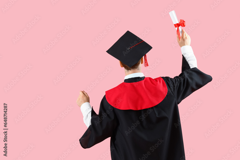 Male graduate student with diploma on pink background, back view