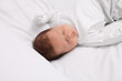 © New Africa - Cute newborn baby sleeping on white bed