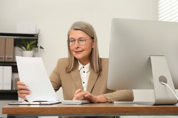 Poster - Senior accountant working at wooden desk in office