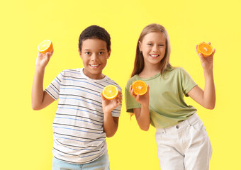 Wall Mural - Little children with fresh citruses on yellow background