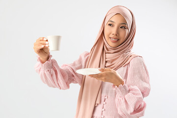 Sticker - Beautiful young Asian woman in hijab with cup of coffee on grey background