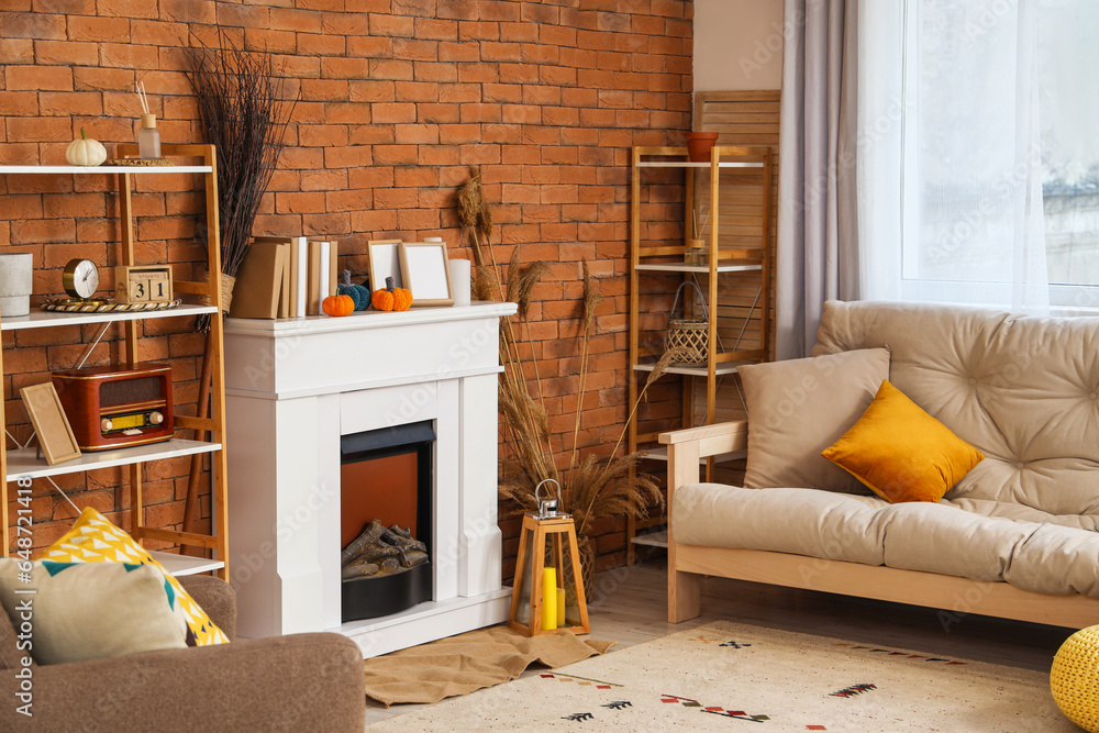 Interior of living room with fireplace, pumpkins and sofa