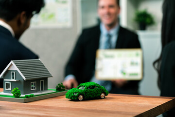 Wall Mural - Mockup electric car with eco-friendly energy infrastructure on table with blurred background of productive business team meeting to contribute natural preservation and sustainable future. Quaint