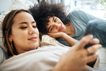 Poster - Phone, social media and an lgbt couple in bed together in the morning for communication or to relax. Love, lesbian and a woman watching a movie or video with her girlfriend in the home bedroom