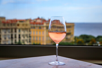 Wall Mural - Glass of rose provencal wine at rooftop bar above the Old Town Vieille Ville with blurred buildings and the Mediterranean Sea in Nice, South of France